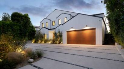 Exterior of a modern-style home with wooden garage door and large windows
