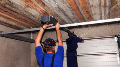 Technicians installing new track and opener for residential garage door