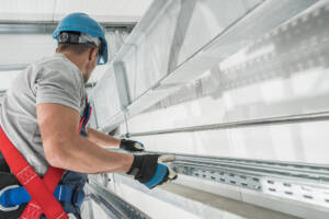 Technician installing commercial garage door inside warehouse