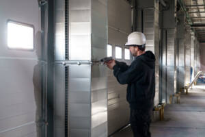 Technician repairing a commercial garage door system
