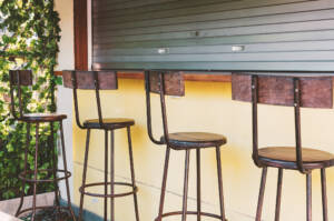 Empty bar stools at counter with closed shutter