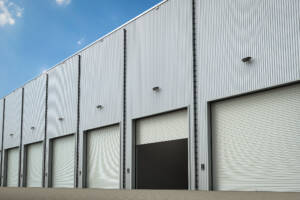 Warehouse exterior with several closed doors and one half open