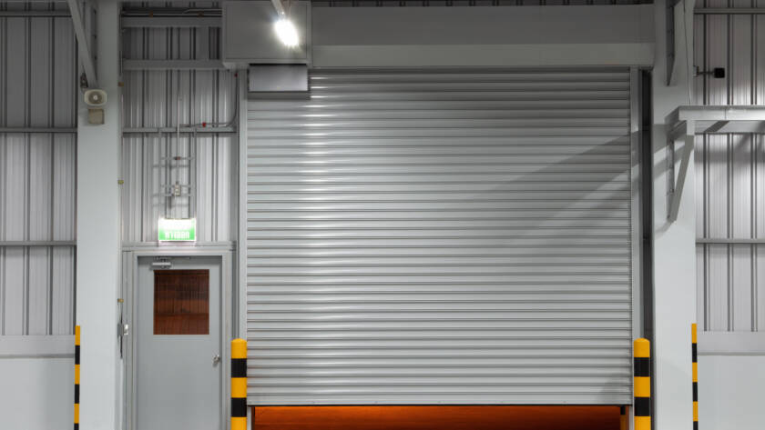 Gray commercial warehouse garage door with regular side door