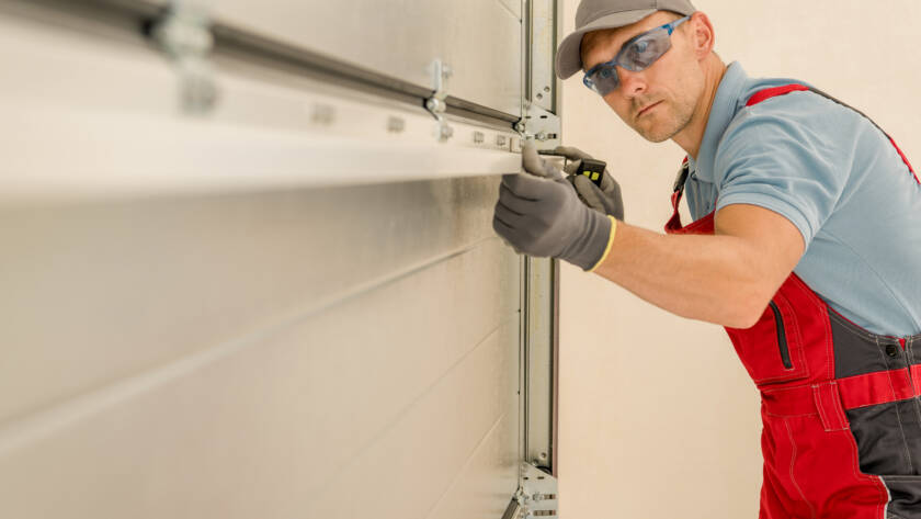 Technician installing brand new residential garage door