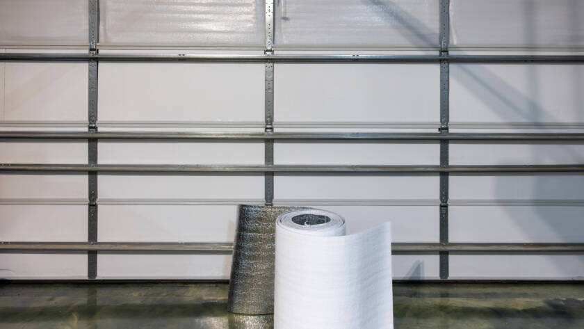 White garage door with roll of insulation