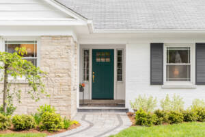 White house with green front door and plants