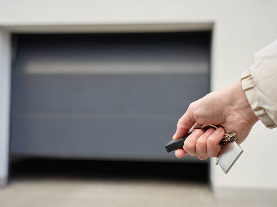 Close-up of hand holding remote and opening garage door